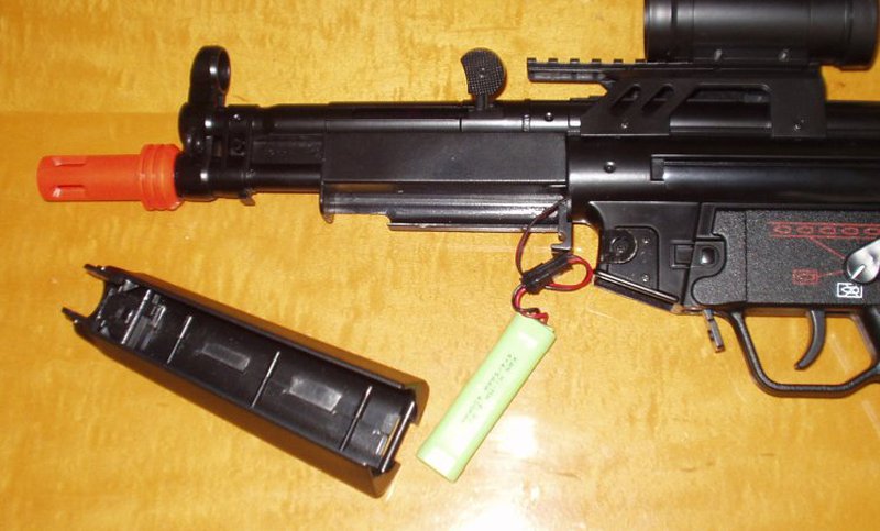 A front-wired MP5 airsoft AEG with the handguard removed, showing the stick battery pack