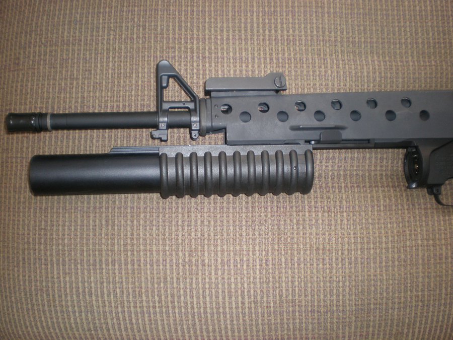 Airsoft M203 40mm 榴彈發射器掛載於 M15A4 下方，槍管前推打開準備裝填彈殼