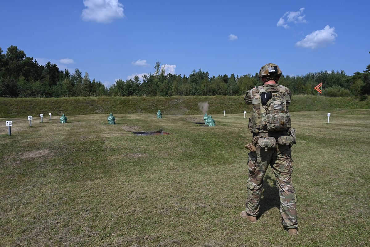 士兵以 M17 射擊綠色跪姿人形起倒靶，地上有 15、20、25 公尺距離標示