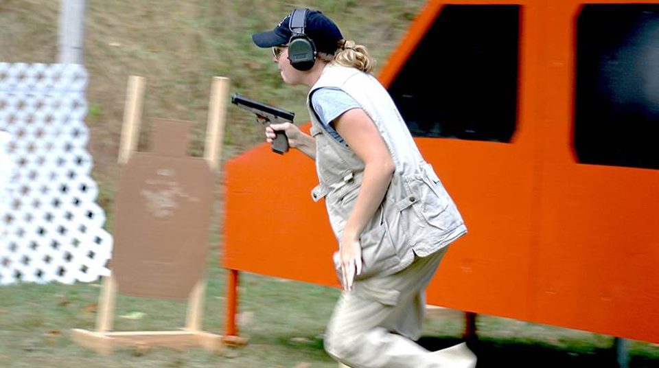 IDPA 選手穿著遮蔽背心跑關卡，槍套藏在背心下