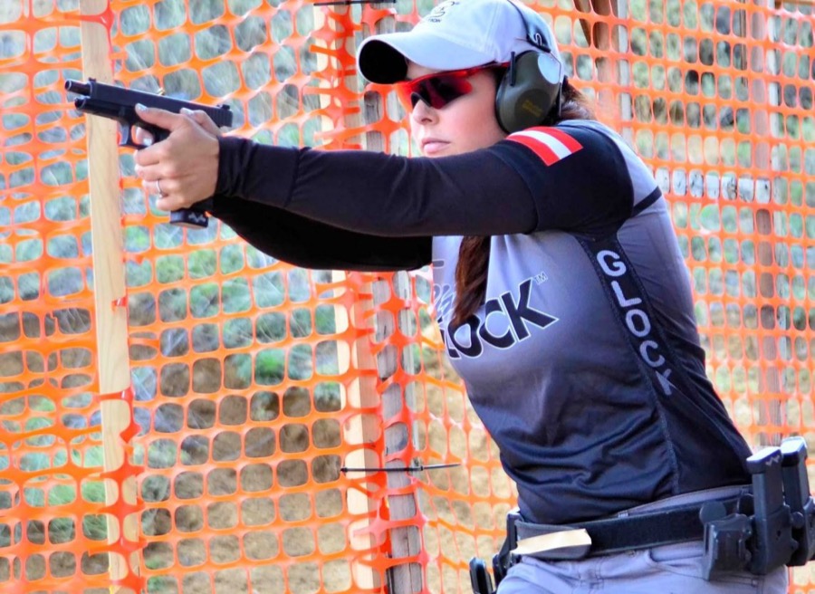 USPSA 選手在關卡中射擊，腰部完整裝備配置清晰可見——槍套、彈匣袋與腰帶是一整套系統（攝影：zinkpics，CC BY-SA 2.0）