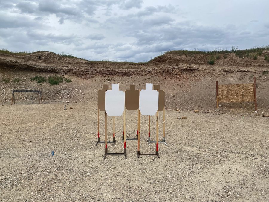 A row of IPSC cardboard targets on a range bay: the metric El Presidente is the same drill at ten metres