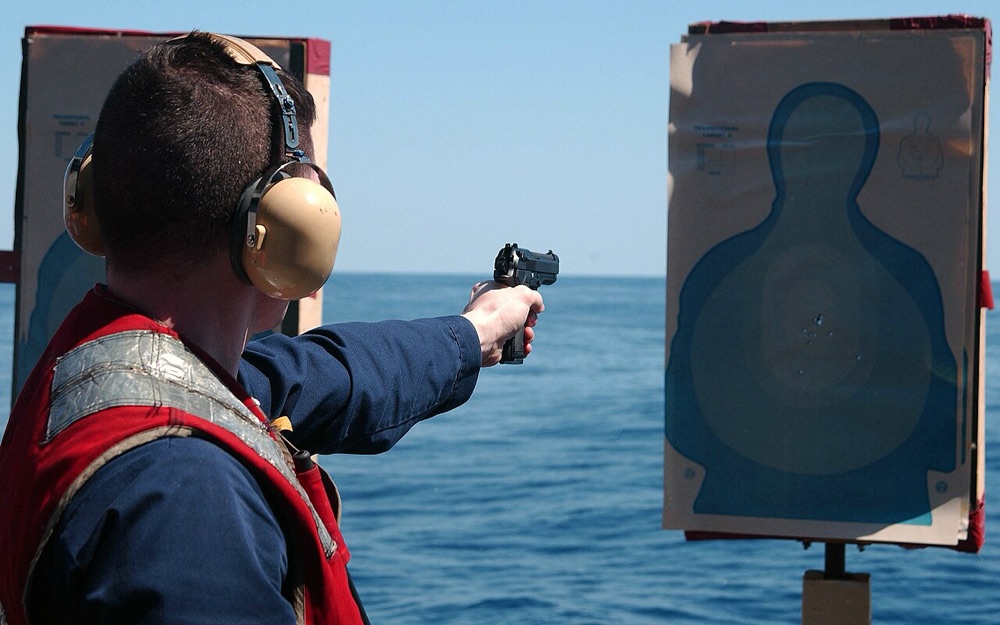 Shooter on a pistol range firing at silhouette targets