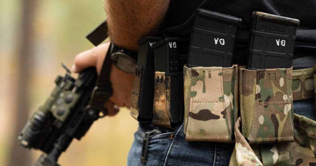 Belt-mounted magazine pouches and magazines laid out with a pistol