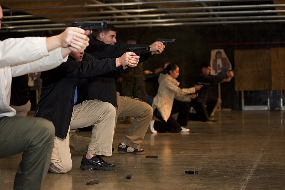 Shooters running speed-reload drills on an indoor range