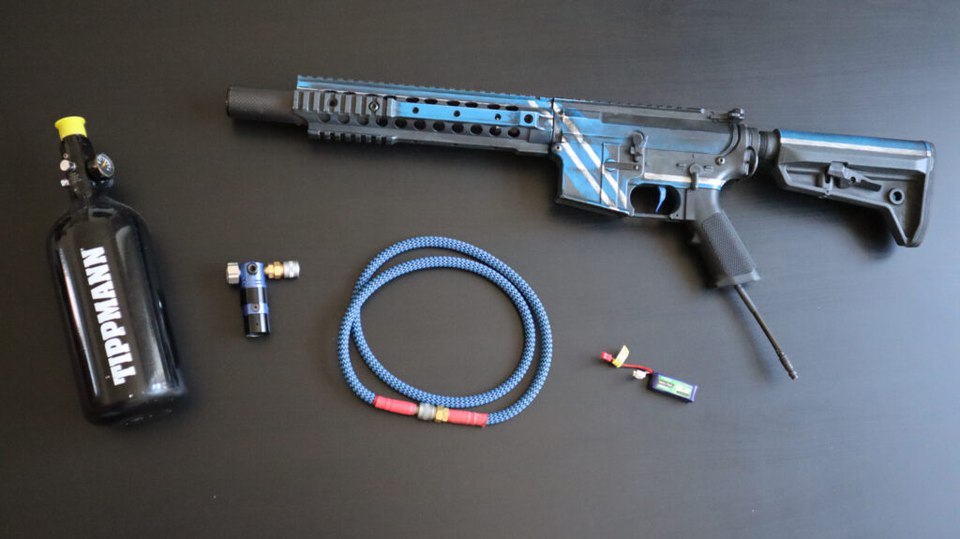 一套 HPA Speedsoft 配置——氣瓶、調壓器與氣管供給一把輕量化 M4，旁邊是驅動扳機板的 LiPo 電池