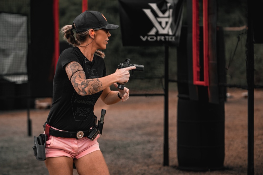USPSA competitors on a stage — the division you enter decides what your gear is measured against